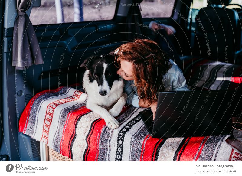 woman and border collie dog in a van. woman working on laptop. Travel concept Woman Dog Van van life Vacation & Travel Notebook Traveling owner