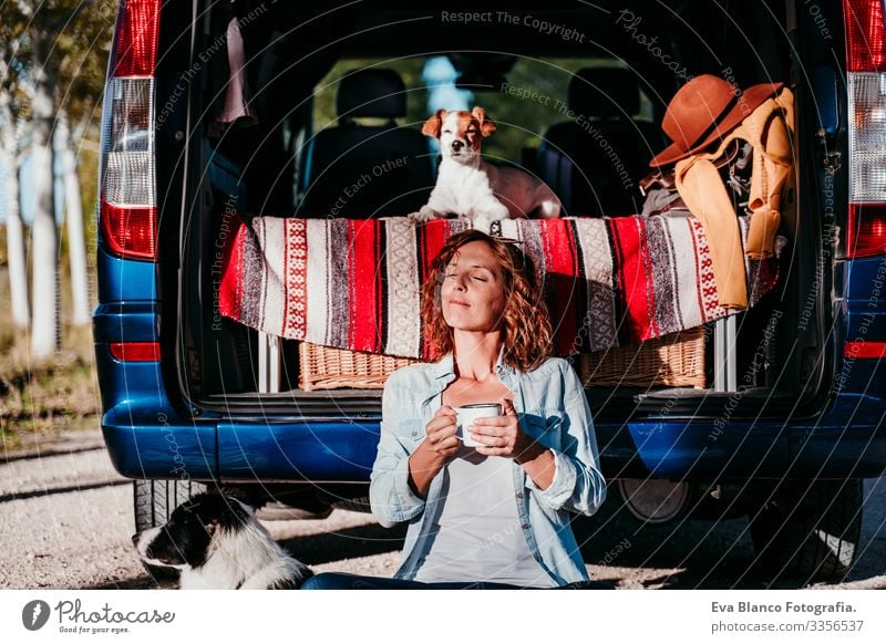 young beautiful woman drinking coffee or tea camping outdoors with a van and her two dogs. Travel concept Drinking Tea Coffee Teapot Woman Dog border collie Van