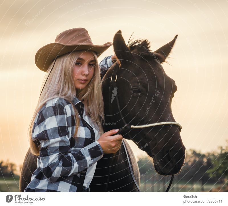young girl dressed in a cowboy hat with a horse at sunset Style Face Summer Human being Woman Adults Hand Nature Plant Animal Sky Grass Meadow Village Clothing