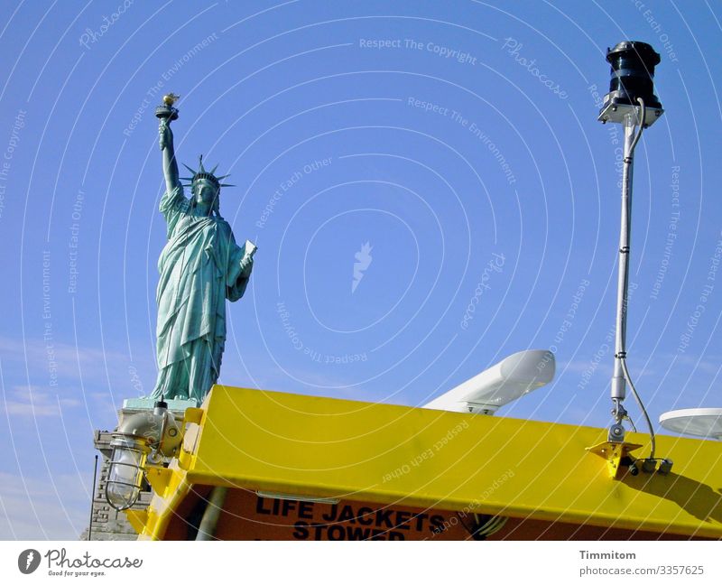 Statue of Liberty in front of blue sky and behind water taxi USA New York Statue of liberty Freedom Tourist Attraction Vacation & Travel Life jacket Sky