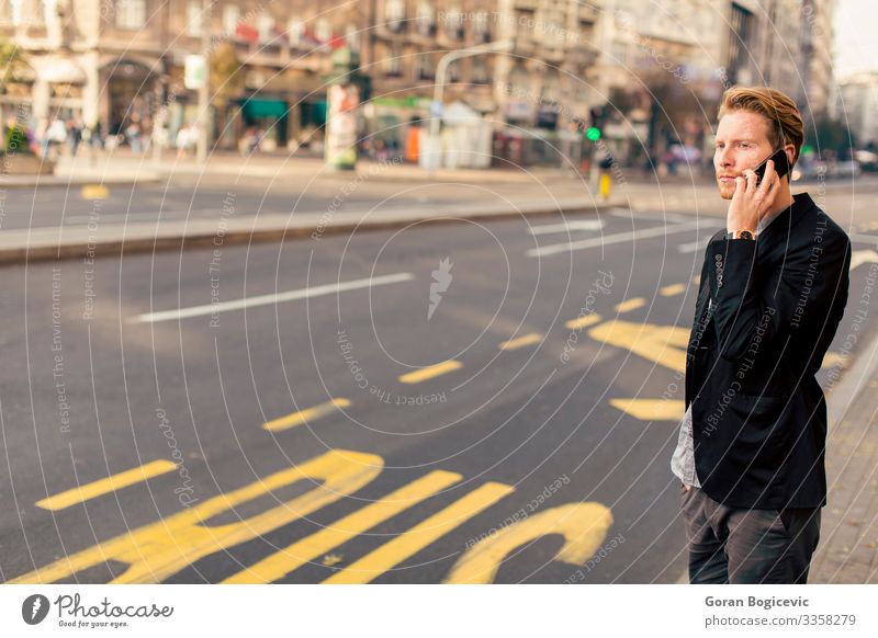 Young man on the street with mobile phone Lifestyle Telephone PDA Technology Human being Youth (Young adults) Man Adults Facial hair 1 18 - 30 years Autumn