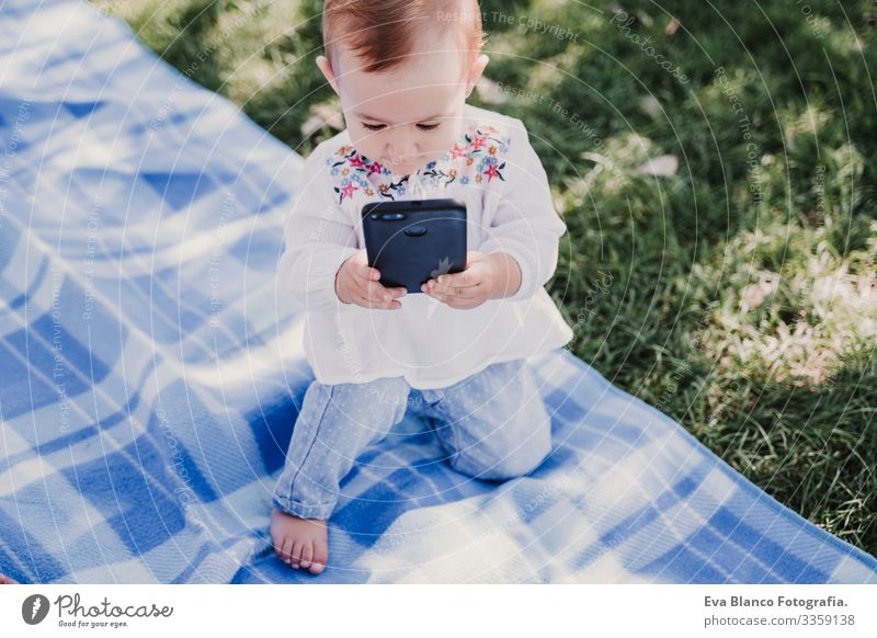 happy baby using mobile phone outdoors. technology concept Mother Baby Cellphone Technology Together Child Parenting Girl Joy Sunbeam Parents Spring parenthood