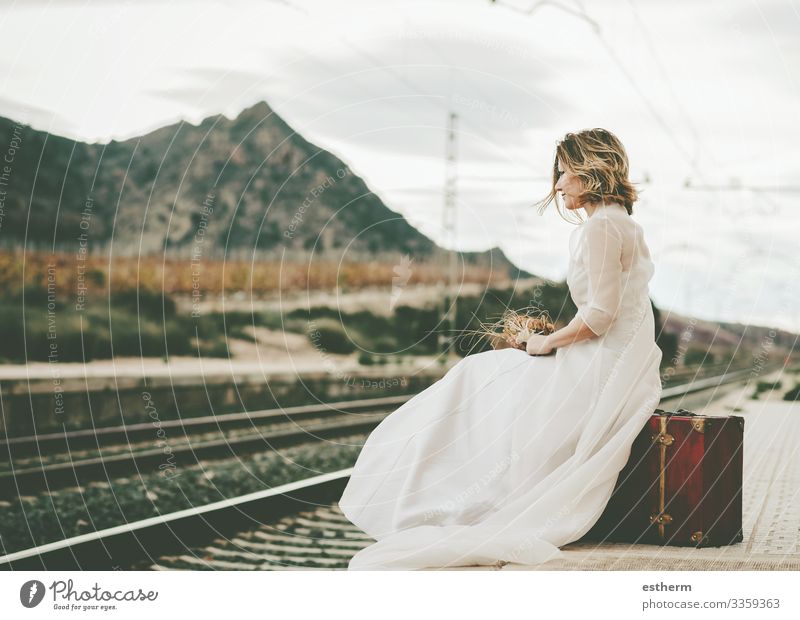 Pensive bride with a red suitcase on the train tracks outdoor Lifestyle Elegant Style Beautiful Vacation & Travel Adventure Freedom Wedding Human being Feminine