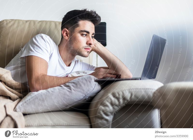 Young male man relaxing on sofa while using laptop Lifestyle Happy Relaxation Leisure and hobbies House (Residential Structure) Sofa Living room