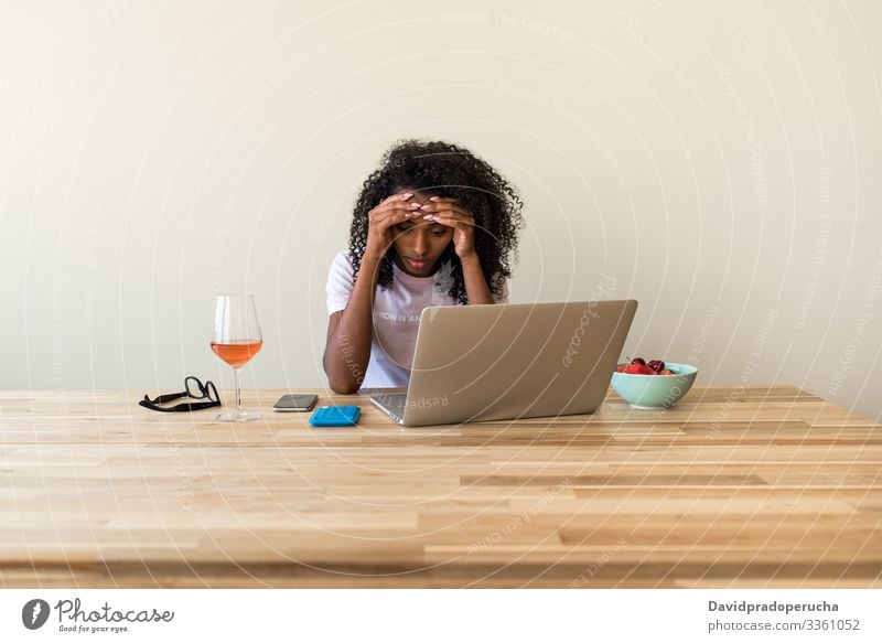 African American female freelancer using laptop at home woman table wine chill browsing weekend ethnic african american black alone beverage refreshment remote