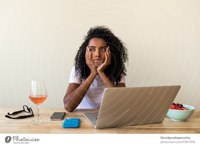 African American female freelancer using laptop at home woman table wine chill browsing weekend ethnic african american black alone beverage refreshment remote