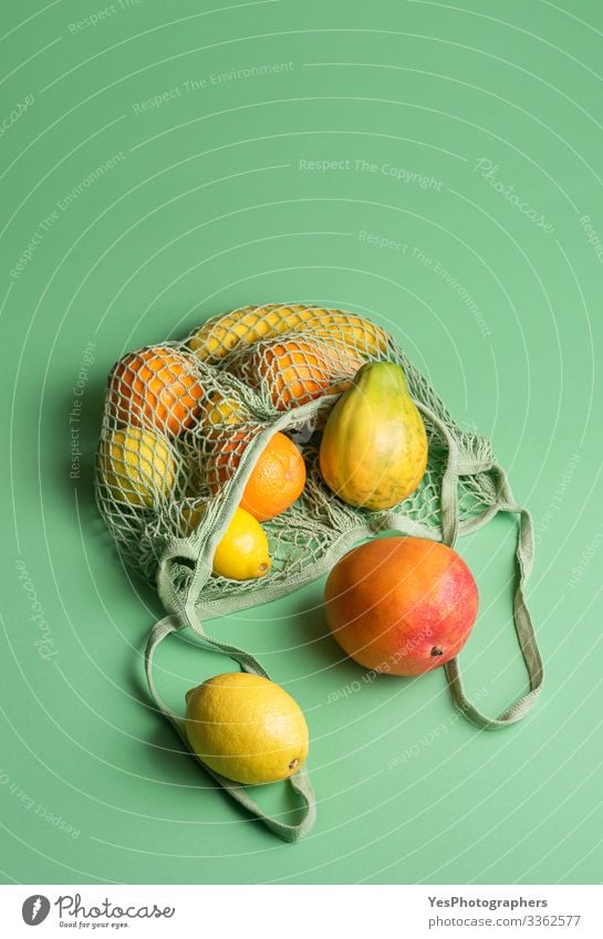 Ripe tropical fruits in a net shopping bag. Buying fruits Fruit Orange Healthy Eating Green above view buying fruits colorful diet food eco-friendly packaging