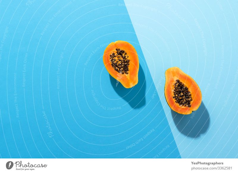 Fresh papaya fruit cut in half on blue background Fruit Dessert Organic produce Healthy Eating Juicy above view Blue background blue shades colorful diet food