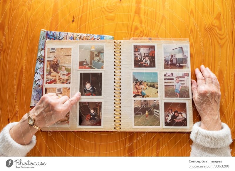 Top view of a senior caucasian woman looking at an old photo album themes of memories nostalgia photos retired picture elderly wife together pensioner family