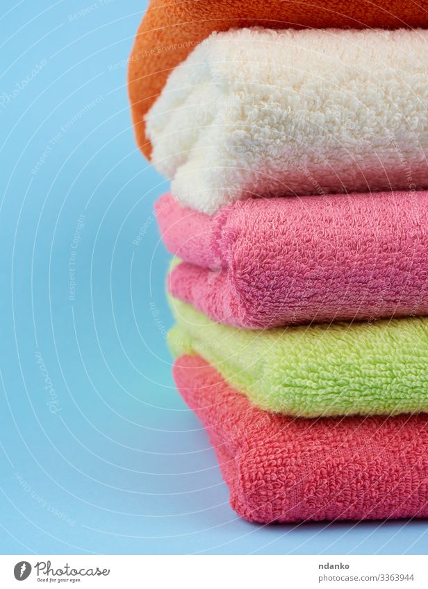 Stack of bath towels on wooden background. White and pink cotton