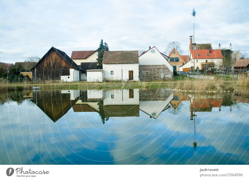 Rural franconian houses situated at an idyllic pond which are reflected in it Franconia carp pond Sky Clouds Winter Reflection Calm Environment Small Town Idyll