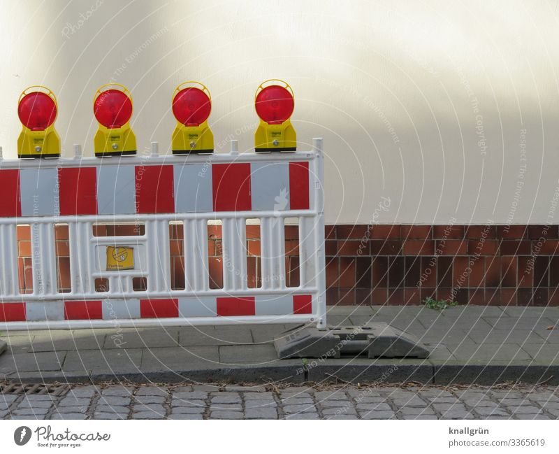 Blocking off a construction site with 4 red warning lights on a pavement cordon Sidewalk Reddish white Striped Protection Safety Structures and shapes Pattern