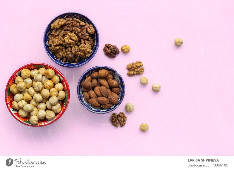 Assortment mix of nuts in bowls on pink Vegetable Nutrition Vegetarian diet Diet Plate Bowl Table Group Natural Above Pink Decline Snack Almond hazelnuts