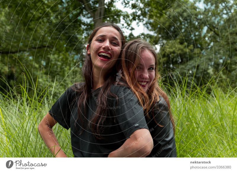 Portrait of Two Pretty Young Women Hugging and Smiling Outdoors women young adult day beauty beautiful women natural beauty females Indian ethnicity 2 people
