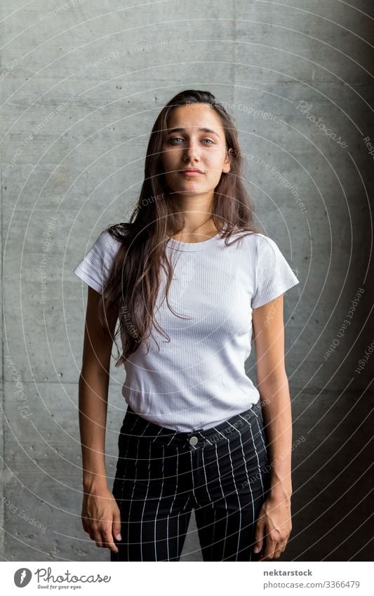 Young Woman in Front of Concrete Wall Indoors - a Royalty Free