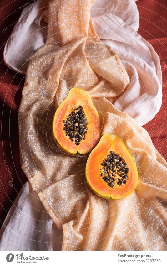 Ripe papaya fruit halves on orange shades tablecloths. Fruit Dessert Organic produce Exotic Healthy Eating Orange above view colorful cut in half diet food