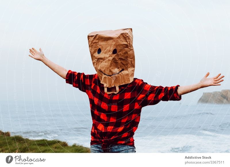 Person with paper bag on head jumping on shore plastic package ecology concept environment person gesture sign nature pollution problem packet polyethylene