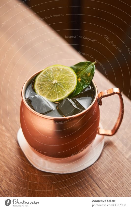 Moscow Mule cocktail in copper mug alcohol classic moscow mule vodka whiskey drink beverage lime beer ginger bar yellow counter cold luxury aperitif traditional