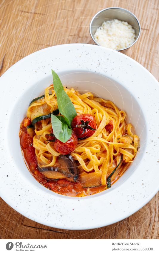 Stylish decorated pasta with courgette spaghetti italian food restaurant tomatoes basil dish high cuisine delicious plate sauce gourmet dinner meal tasty cooked