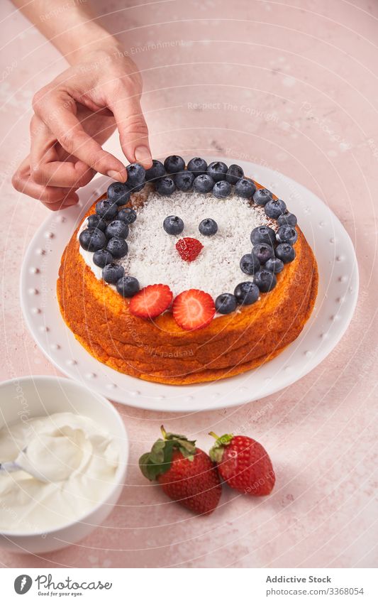 Faceless lady serving cake with berries baked dessert cooking woman decorating blueberry strawberry sour cream female chef homemade household penguin plate dish
