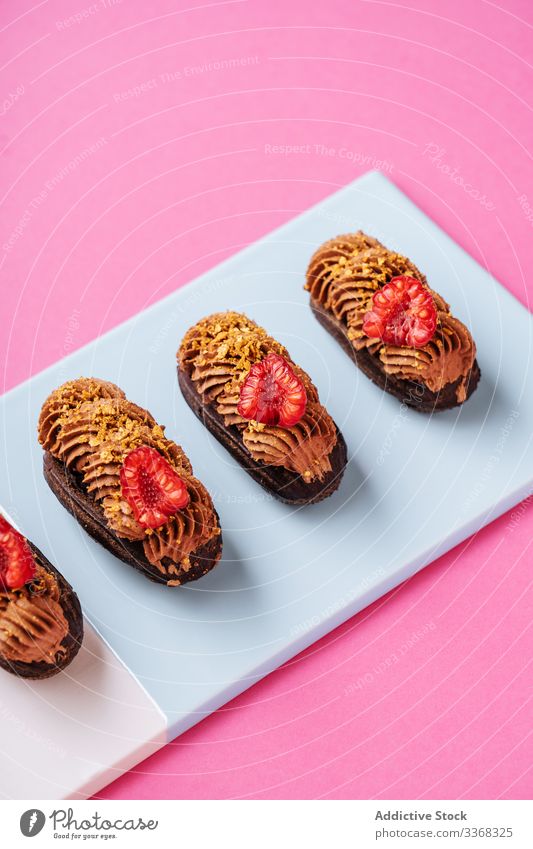 Chocolate eclairs with fresh raspberries dessert sweet caramel cream chocolate raspberry board colorful bright food pastry tasty cuisine dish delicious yummy