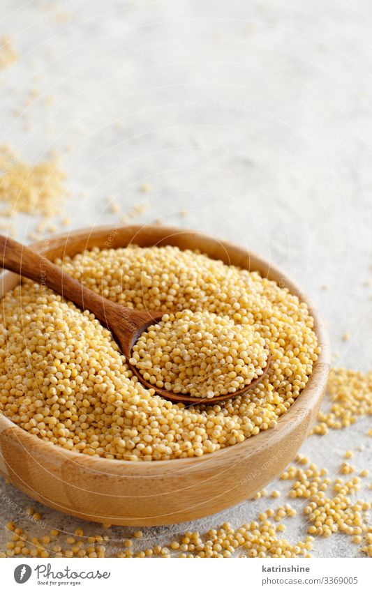 Raw dry hulled millet in a wooden bowl with a spoon Vegetarian diet Diet Bowl Spoon Wood Natural Yellow Gray Millet Dried fiber food healthy Ingredients