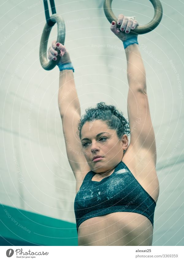 Woman athlete hangs of the rings in the gymnastic Lifestyle Body Wellness Sports Human being Adults Hand Fitness Muscular Strong Determination Effort abs Action