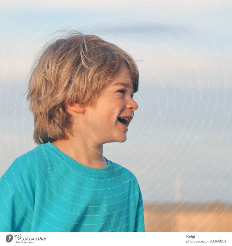 Portrait of a laughing child, half profile, half-length dark blond hair, in front of a blue-grey sky Vacation & Travel Summer vacation Human being Masculine