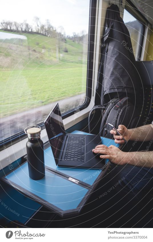 Man using laptop and phone inside train. Swiss train interior Vacation & Travel Tourism Trip Chair Table Work and employment Transport Passenger traffic