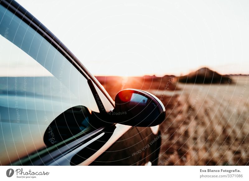 close up view of a car and rear mirror at sunset on a field. Travel concept travel sunny countryside yellow nobody sporty utility nature destination vehicle