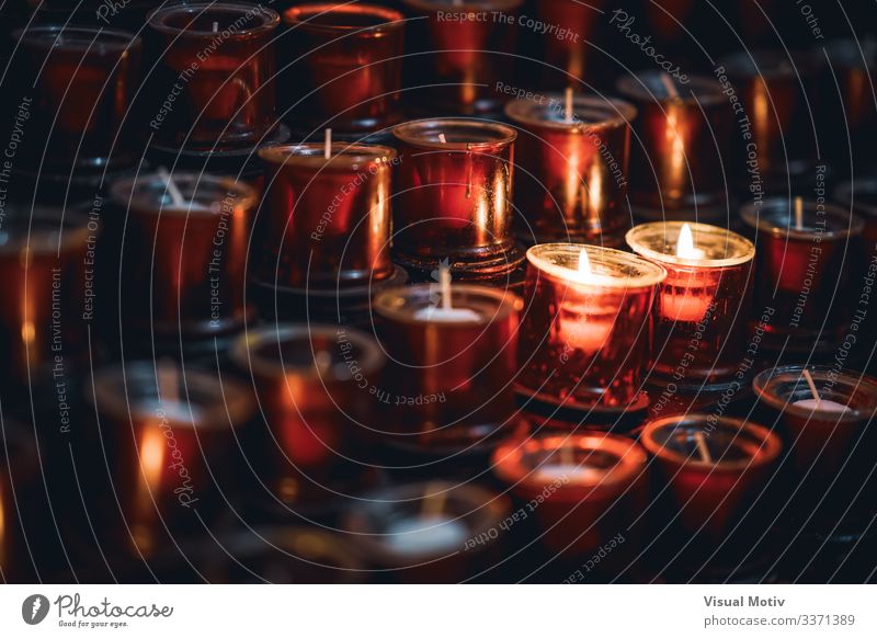 Two burning candles among several rows of red candles in a church Relaxation Meditation Warmth Church Candle Bright Hope Colour Peace Belief Religion and faith