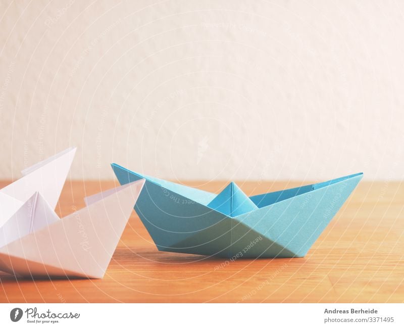 Teamwork business concept with paper boat on a wooden table background blue color compass competition copy space creative creativity difference different