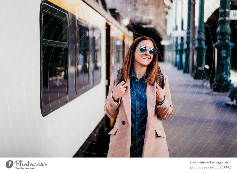 happy young woman walking at train station. Travel concept screen destination travel backpack caucasian europe railway waiting track wagon arrival long urban