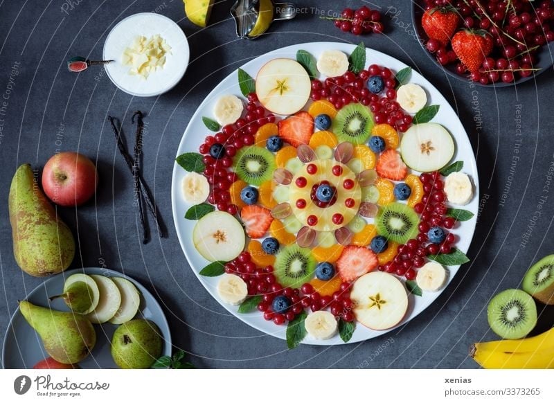 Delicious mixed fruit salad arranged as a mandala on a white plate, with delicious cream and many healthy ingredients Fruit salad Food Apple Vanilla pod Pear