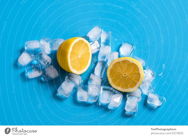 Fresh lemon sliced in half on ice cubes. Citrus fruits Fruit Cold drink Healthy Eating Blue background citrus fruit colorful Copy Space cut in half food