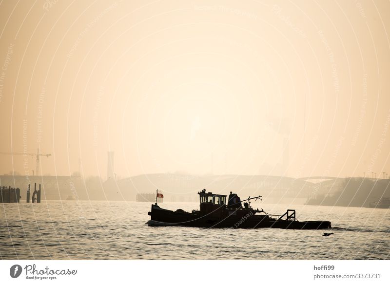Silhouette of a small tugboat in Hamburg harbour with early morning fog and rising sun Water Sky Sunrise Sunset Sunlight Autumn Bad weather Fog Coast River bank