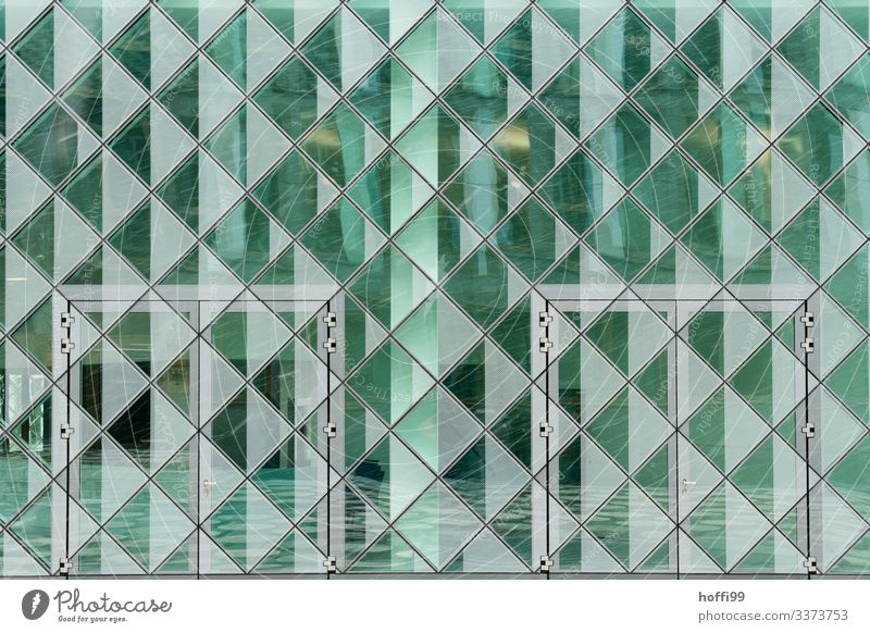 green reflecting transparent facade with doors and snow Glas facade reflection Green square Pattern square structure urban Modern Atchitecture