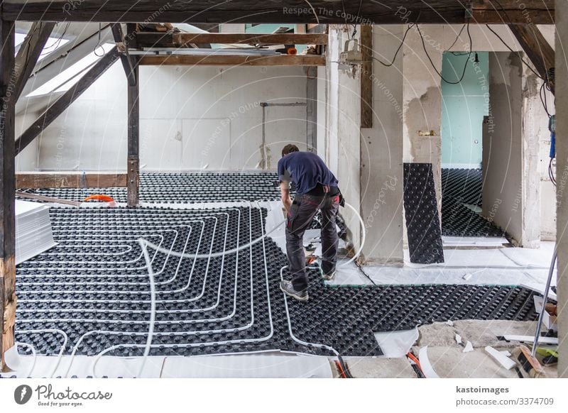 Pipe fitter mounting underfloor heating. Life House (Residential Structure) Work and employment Industry Climate Places Tube Plastic Under Safety (feeling of)