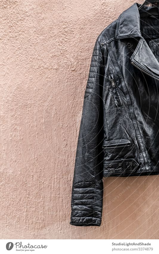 Black leather jacket on pink wall black zipper pocket fashion style stylish shiny cool rock rocker metal heavy metal clothing clothes apparel outfit fetish wear