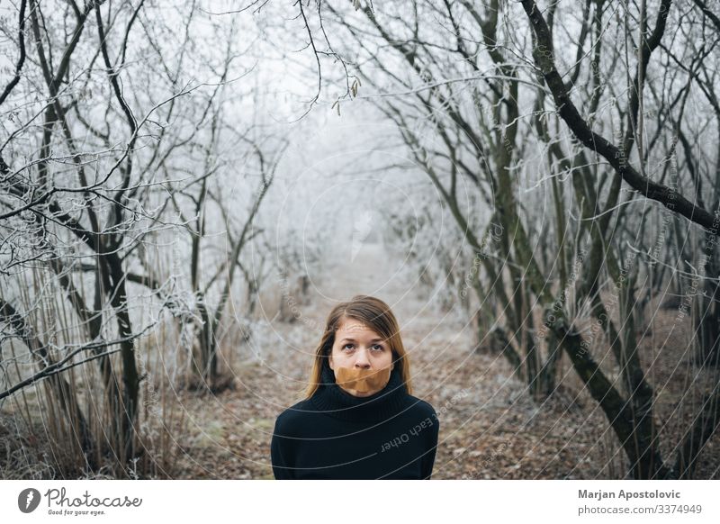 Woman with tape on her mouth in cold winter forest - a Royalty Free Stock  Photo from Photocase