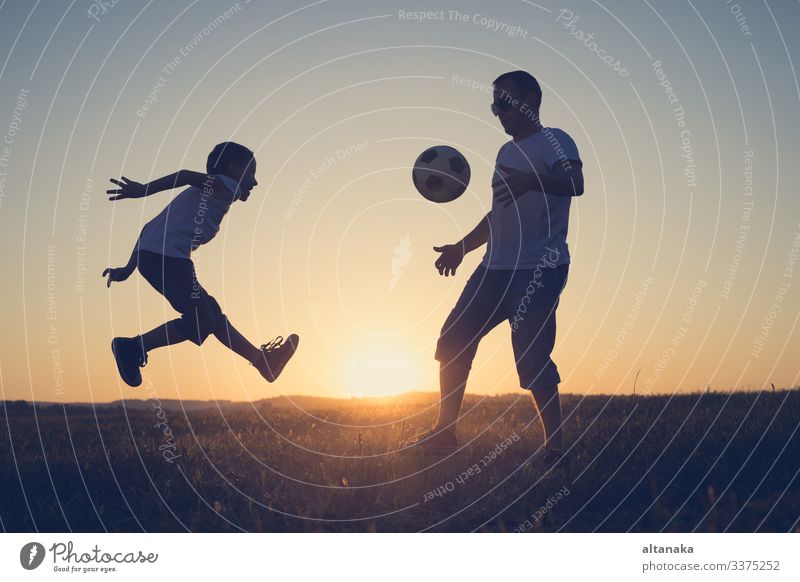 Father and young little boy playing in the field with soccer ball. Concept of sport. Lifestyle Joy Happy Leisure and hobbies Playing Summer Sports Soccer Child