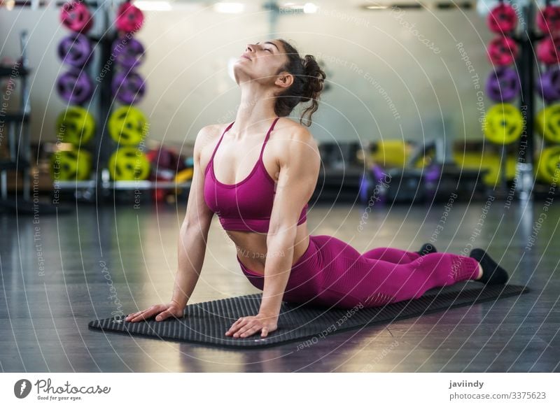 Young woman Doing Stretching Exercises on a yoga mat - a Royalty