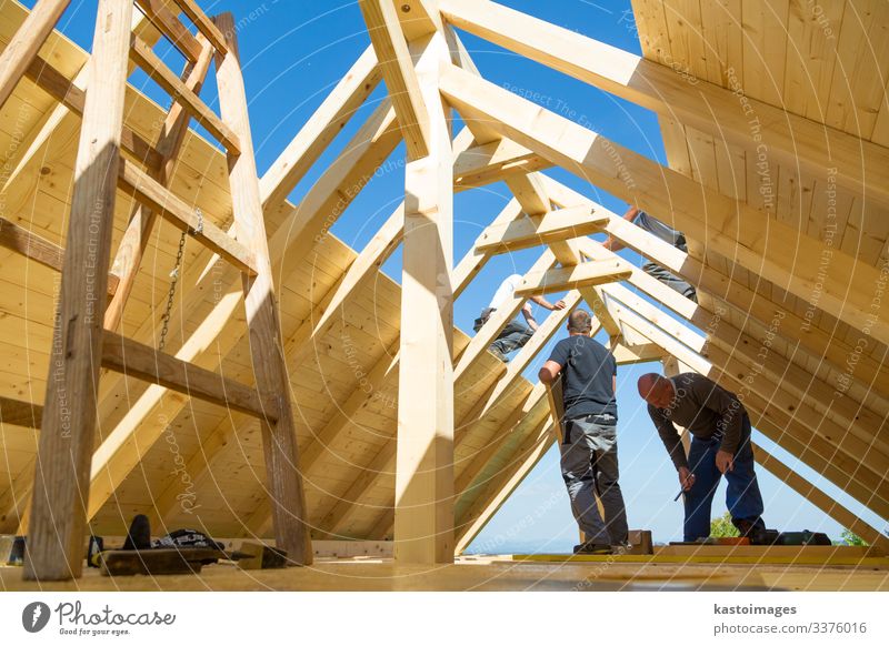 Builders at work with wooden roof construction. House (Residential Structure) Work and employment Craftsperson Construction site Industry Tool Hammer