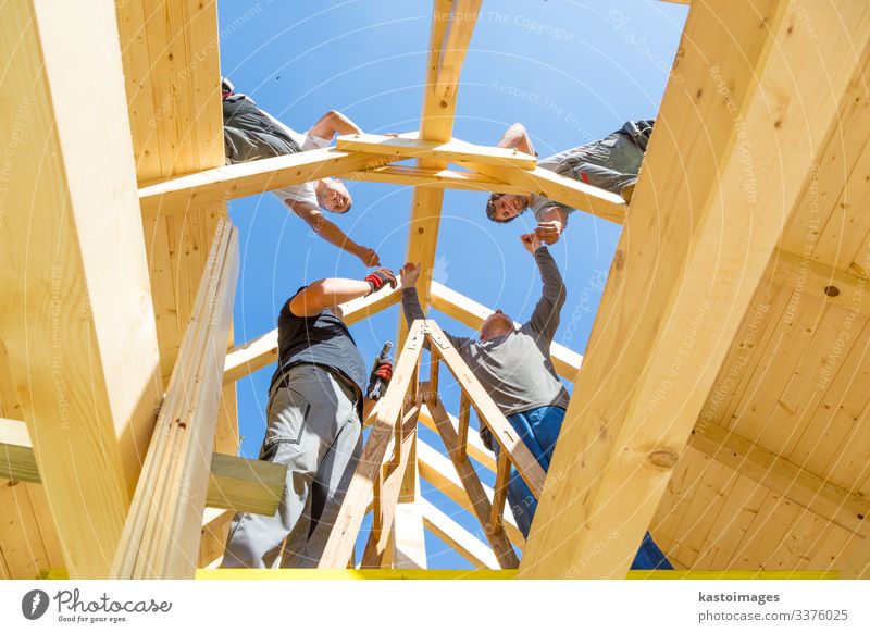 Roof builders mounting prefabricated wooden roof construction. Construction industry concept. House (Residential Structure) Work and employment Craftsperson