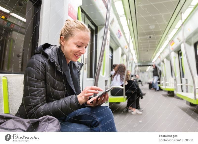 Young girl reading from mobile phone screen in metro. Lifestyle Vacation & Travel Trip Decoration Business Telephone Cellphone PDA Screen Human being Woman