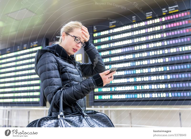 Woman at airport checking flight information on phone app. Vacation & Travel Tourism Trip Winter Decoration Telephone PDA Aviation Human being Adults Airport
