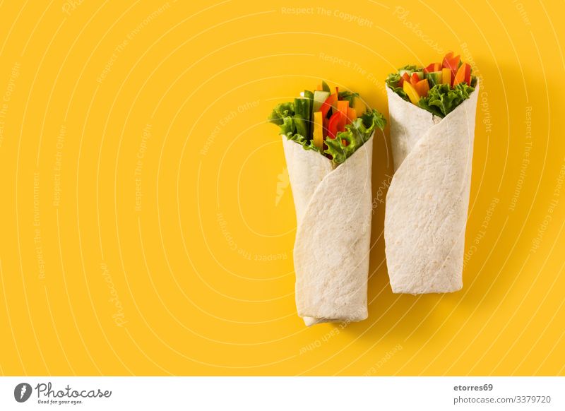 Vegetable tortilla wraps on yellow background. Top view copy space burrito carrot cucumber diet fajita food fresh green healthy isolated lettuce mexican mix