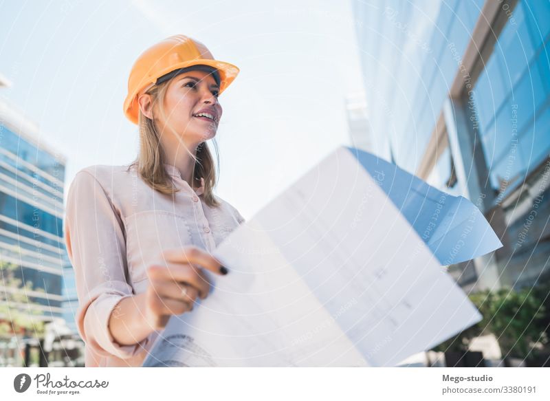 Professional architect holding blueprints outdoors. woman professional engineer business architecture consultant urban builder working city employee protective