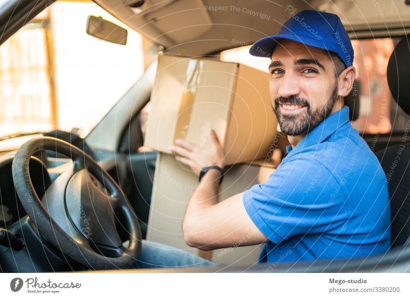 Delivery man driving van with cardboard boxes on seat. male service package delivery shipping industry work send office closeup logistic consumer carrying