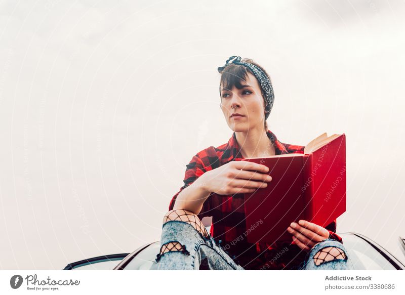Thoughtful casual woman with book at seashore car read sitting teenager female hipster thoughtful dream wistful pensive transport trip journey vacation travel
